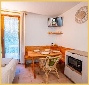 a dining room with a table and a tv on the wall at Chez Sebastien I Studio I Bernex in Bernex