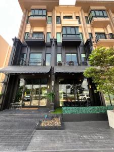 a building with glass doors and a courtyard at The Eiffel Cafe and Hotel in Ban Khlong Lat Bua Khao