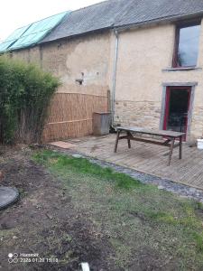 a bench sitting on a deck next to a building at house in Saint-André-des-Eaux