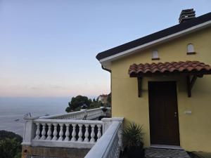 a yellow house with a balcony with a view of the ocean at Monaco' hills appartement in Roquebrune-Cap-Martin