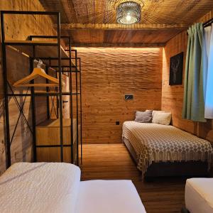 two beds in a room with wooden walls at Haus Adrian in Wald am Arlberg