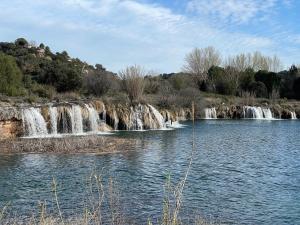 a couple of waterfalls in the middle of a river at Hostal Guadiana in Ruidera