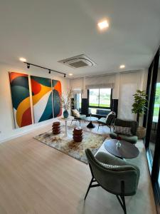 a living room with furniture and a painting on the wall at The Eiffel Cafe and Hotel in Ban Khlong Lat Bua Khao