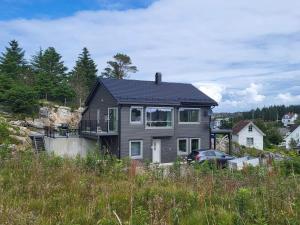 a black house on top of a hill at 8 person holiday home in Hellesøy-By Traum in Bøvågen