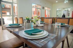 a wooden table with green napkins and plates on it at Chamba Valley Exotic Hotel in Lusaka