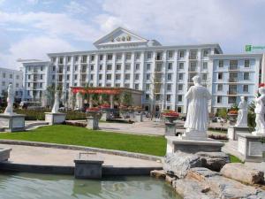 a hotel with statues in front of a fountain at Datong Hotel in Datong