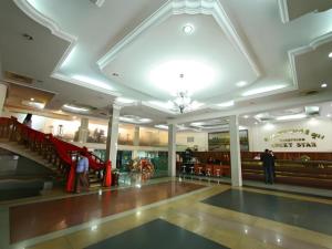 a lobby with a staircase and people in a building at Lucky Star Hotel in Phnom Penh