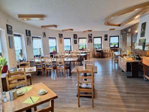 a restaurant with wooden tables and chairs and windows at Landhotel Eifelblick in Stadtkyll