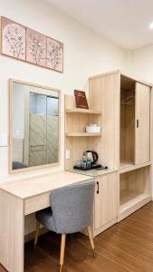 a desk with a mirror and a chair in a room at New Star Hotel Tay Ninh in Tây Ninh