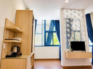 a living room with a tv and a large window at New Star Hotel Tay Ninh in Tây Ninh