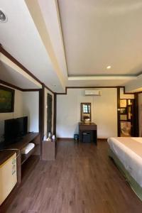 a hotel room with a bed and a tv and a room at Phuingfah in Ban Tai