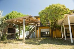 a house with a wooden staircase in the yard at La Casa del Caminante in Aguas Dulces