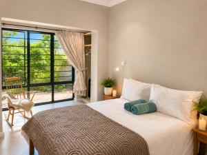 a bedroom with a bed and a large window at Sandy Toes Home in Plettenberg Bay +45 photos