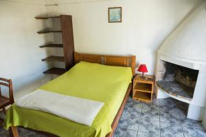 a bedroom with a bed and a fireplace at La Casa del Caminante in Aguas Dulces