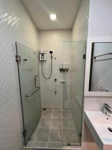 a shower in a bathroom with a glass shower stall at The Eiffel Cafe and Hotel in Ban Khlong Lat Bua Khao +104 photos