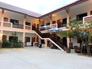 a building with stairs and umbrellas in the courtyard at N-Joy Place in Surin