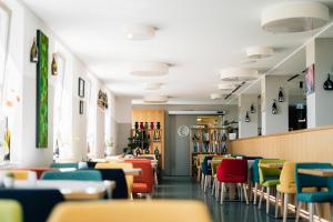 a dining room with colorful chairs and tables at Vogelsburg in Volkach