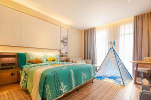 a bedroom with a bed with a toy pyramid on it at Wanda JIN Baise in Qitang +287 photos