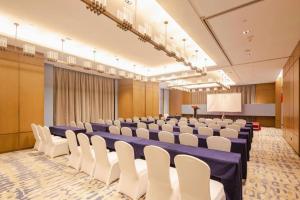 a conference room with blue tables and white chairs at Wanda JIN Baise in Qitang