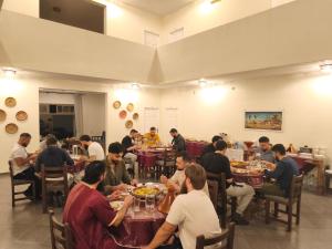 a group of people sitting at tables in a restaurant at Tazgha house in Essaouira