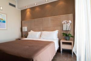 a bedroom with a large bed with a wooden headboard at Casa del Mar - Residence & Beach Resort in Roseto degli Abruzzi +37 photos