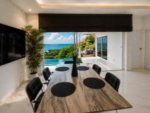 a dining room with a table and chairs and a large window at White Villa Lanta in Ko Lanta