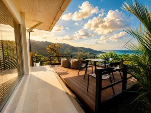 a patio with a table and a view of the ocean at White Villa Lanta in Ko Lanta