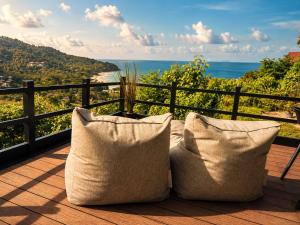 a balcony with two pillows and a view of the ocean at White Villa Lanta in Ko Lanta