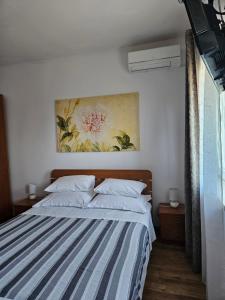 a bedroom with a bed with a painting on the wall at B&B Eva in Ičići