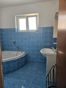 a blue tiled bathroom with a tub and a sink at B&B Eva in Ičići +36 photos