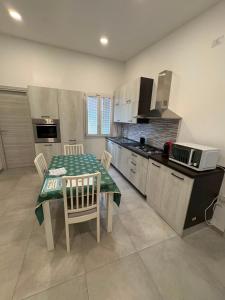 a kitchen with a table and chairs in a kitchen at Blue Sky Sardinia in Sorso