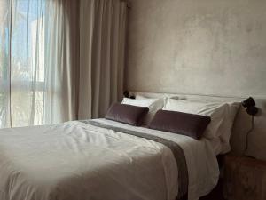 a bedroom with a white bed with two pillows at Casa Mayab in León