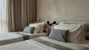 two beds with white sheets and pillows in a room at Casa Mayab in León