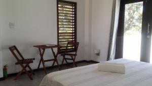 a bedroom with a bed and two chairs and a table at dilo tree lodge in Sigatoka