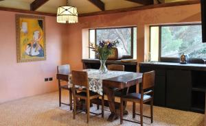 a dining room with a table with a vase of flowers on it at Villa Borgo Musolino in Messina +17 photos