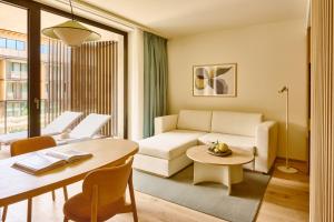 a living room with a couch and a table at Falkensteiner Resort Lake Garda in Salò