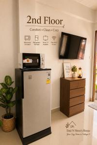 a small refrigerator in a room with a tv at Dad N Mom's House By Thongnak Apartment in Pattaya