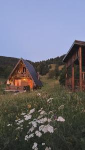 ein Haus und davor eine Wiese mit Blumen in der Unterkunft Monte Casa Sarajevo in Šuštići