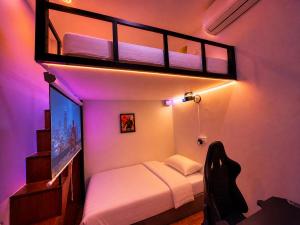 a small room with a bunk bed and a tv at A Hotel Bugis Village in Singapore