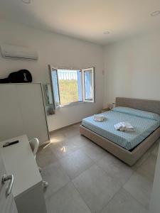 a bedroom with a bed and a window at Blue Sky Sardinia in Sorso
