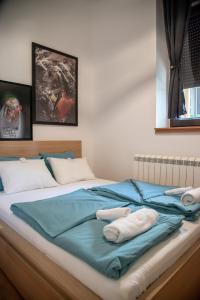 a bed with blue sheets and white towels on it at Vila Plamenac in Divčibare