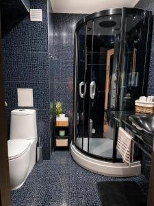a bathroom with a shower and a toilet and a sink at Medius Park Apartment in Sandanski +19 photos