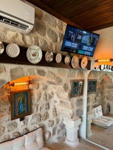 a stone wall with a tv and plates on it at Kasri Reyyan in Mardin