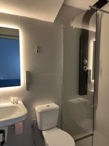 a bathroom with a toilet and a sink and a shower at Lake Breeze in Gjokaj