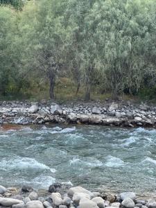 a river with rocks and trees in the background at Ugam Glamping in Khumson