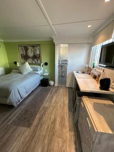 a bedroom with a bed and a bathroom with a sink at Tiny Treasure in Klein Silwermyn