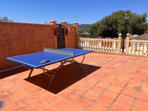 a blue ping pong table on a brick patio at Hotel Sierra de Ubrique in Ubrique