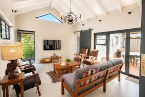 a living room with a couch and a tv at Sandy Toes Home in Plettenberg Bay