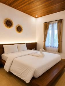 a bedroom with a large bed with a swan on it at Lantis Corp Inn in Sengkol