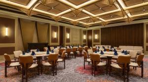 a room with rows of tables and chairs at Lumeirrah Suites in Moga
